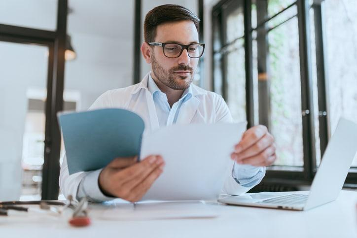 Editorial reviewer cross-checking a medical article draft against source research